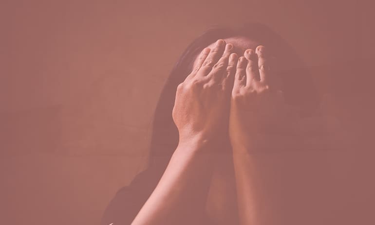 Woman with her hands covering her face